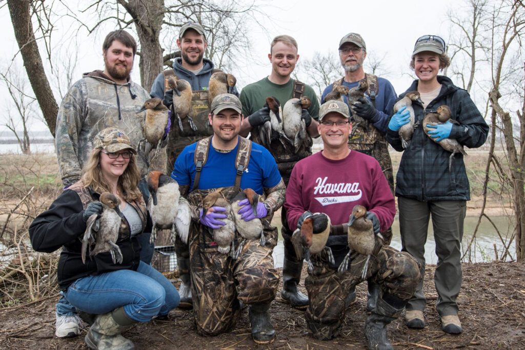 Eight staff members, all holding ducks, 2017.